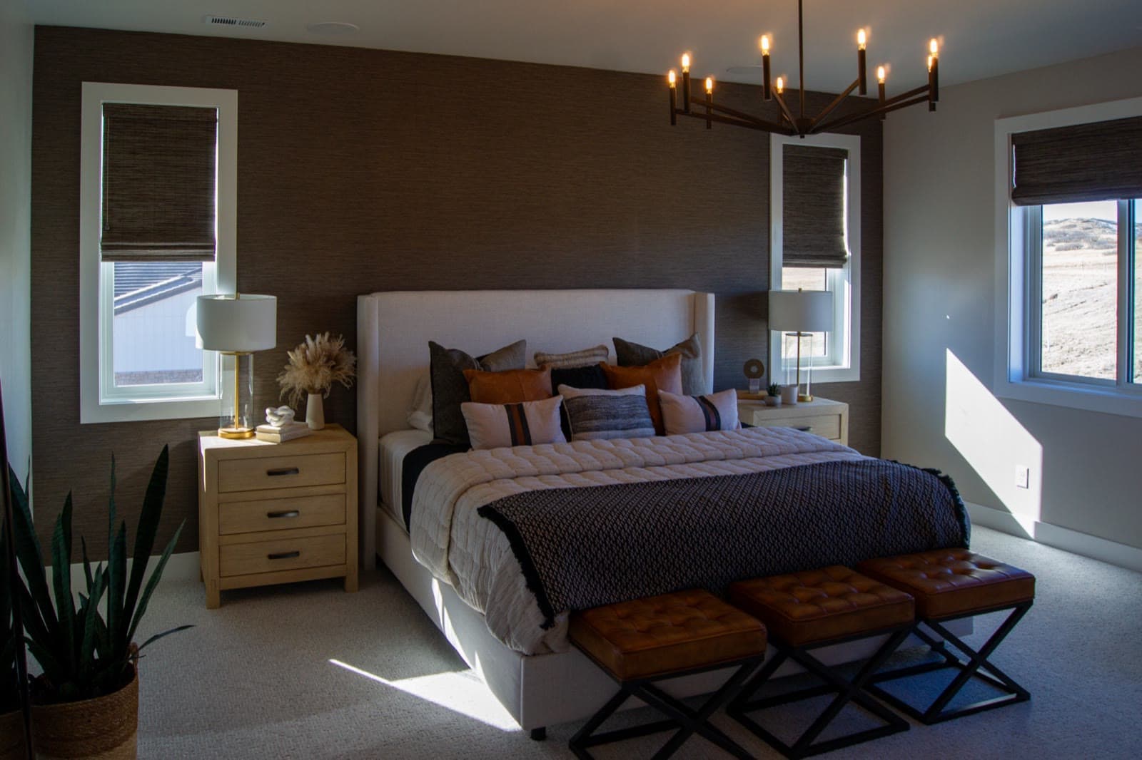 Woven wood Roman shades in a master bedroom with a grasscloth accent wall