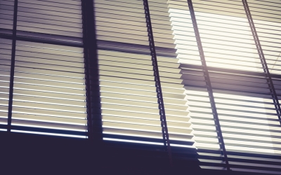 A sunlit window with blinds partially open