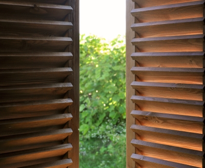 A view of a window with closed wooden shutters