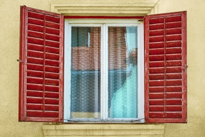 A window with red shutters and a window sill